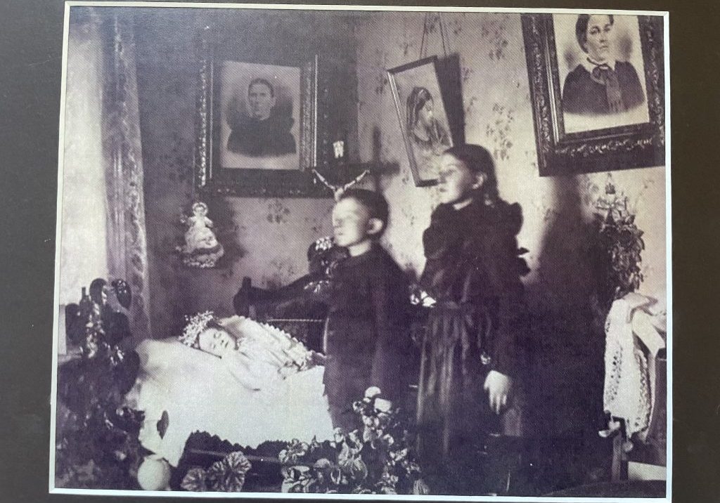 Een laatste foto, hoe men in de Victoriaanse tijd afscheid nam – portret van overleden persoon tussen familieledenlaatste foto, hoe men in de Victoriaanse tijd afscheid nam.